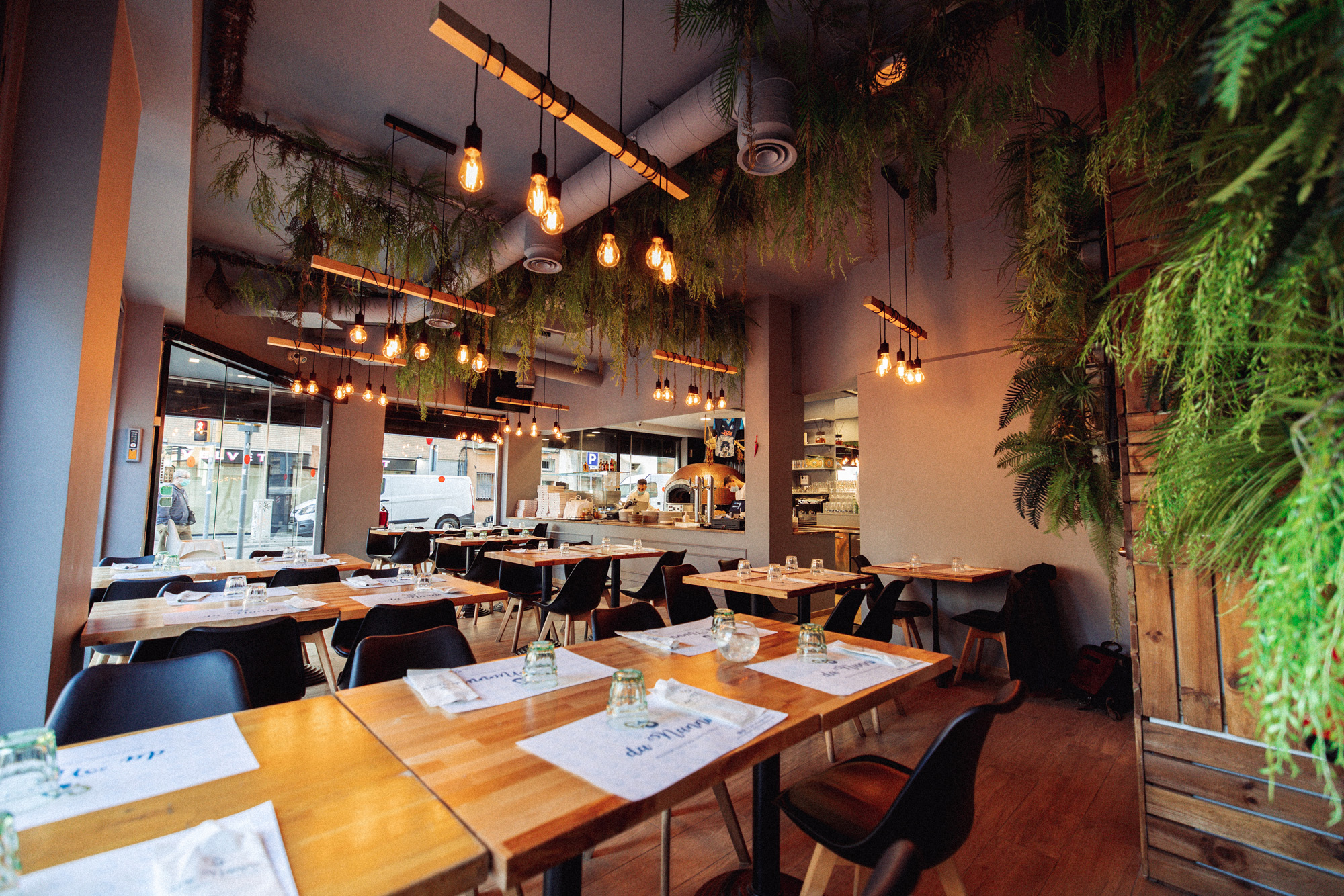 Interior de restaurante napolitano con iluminación decorativa de bolas de cristal y apliques de pared, proyecto de iluminación artesanal en Da Nanni Barcelona.