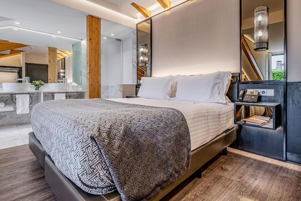 Habitación premium del Hotel Santa Justa en Lisboa con cama doble, iluminación ambiental artesanal, detalles en madera y baño integrado.