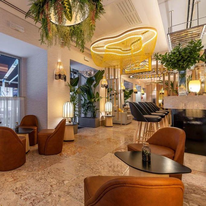 Zona lounge y bar del Hotel Santa Justa en Lisboa con lámparas artesanales, luz ambiental cálida, mobiliario elegante y diseño interior sofisticado.