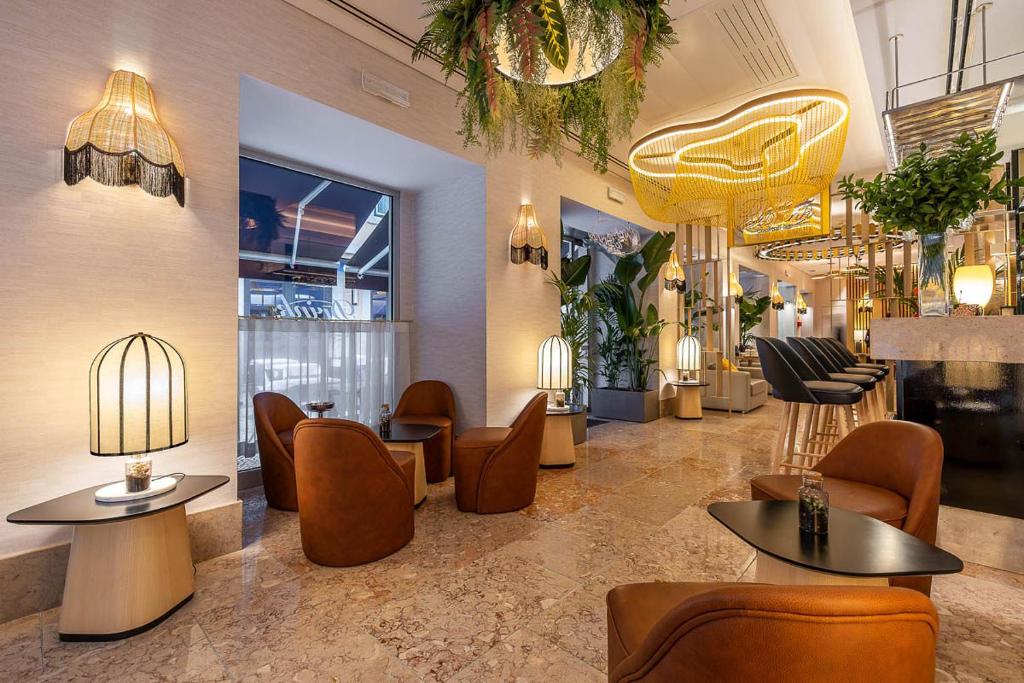 Zona lounge y bar del Hotel Santa Justa en Lisboa con lámparas artesanales, luz ambiental cálida, mobiliario elegante y diseño interior sofisticado.