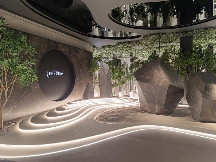 Lobby de XTONE en Vila-real inspirado en un jardín zen, con vegetación interior, superficies porcelánicas, rocas escultóricas e iluminación integrada en el pavimento.