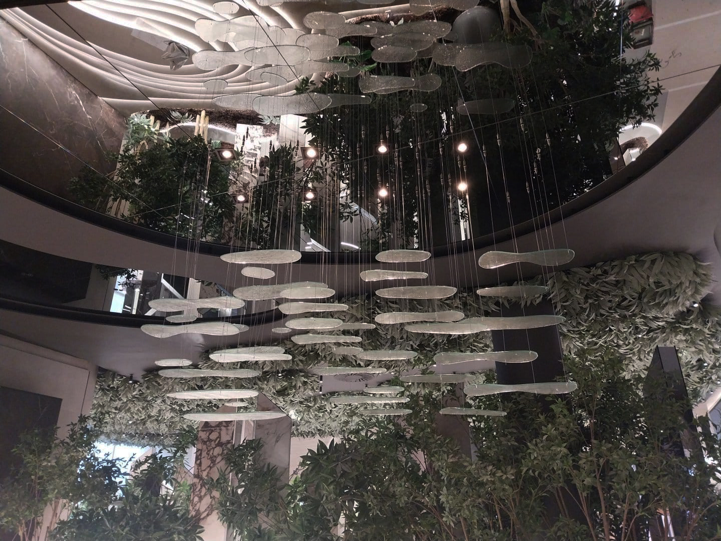 Luminaria suspendida a medida con piezas de cristal artesanal en un lobby inspirado en un jardín zen para el proyecto XTONE en Vila-real.