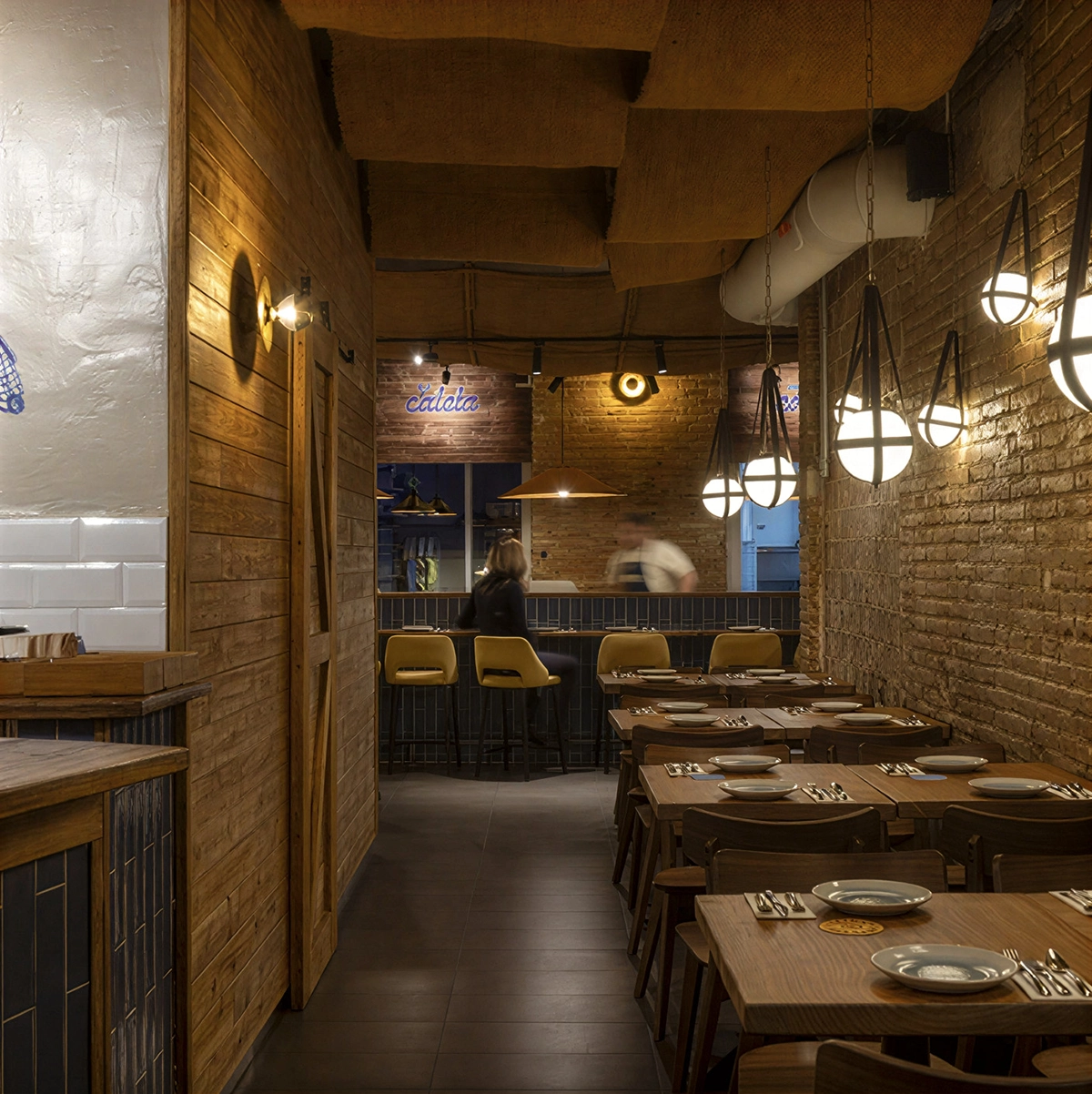 Iluminación colgante artesanal con tulipa opal en taberna cevichera