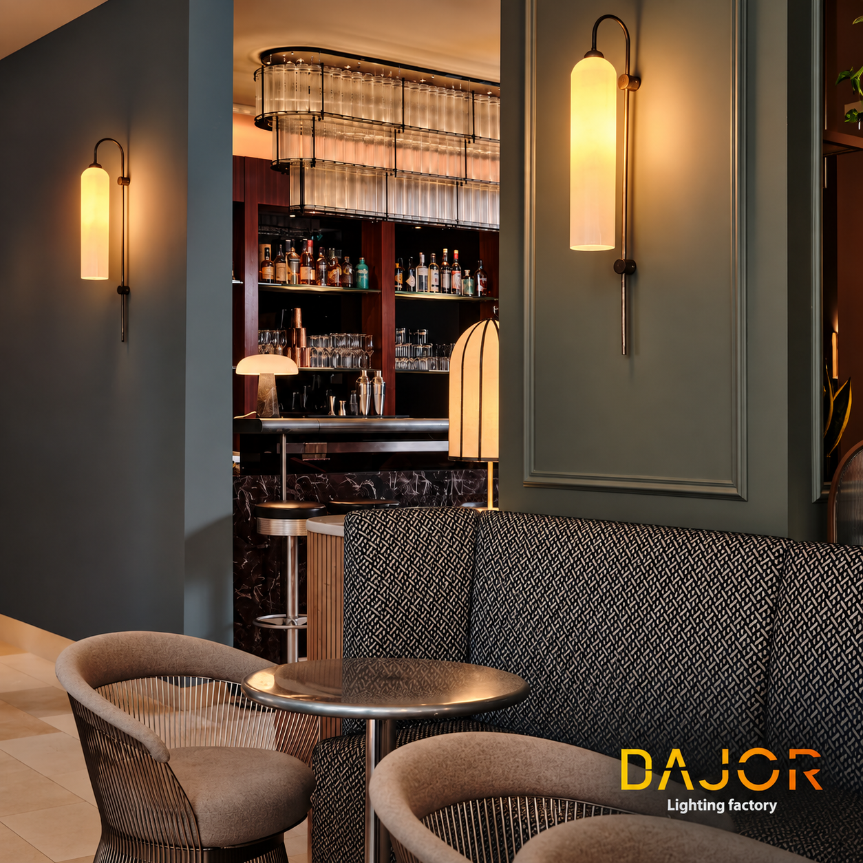 Zona lounge de hotel con apliques verticales de luz cálida, mobiliario tapizado y barra al fondo iluminada con luminarias decorativas DAJOR.