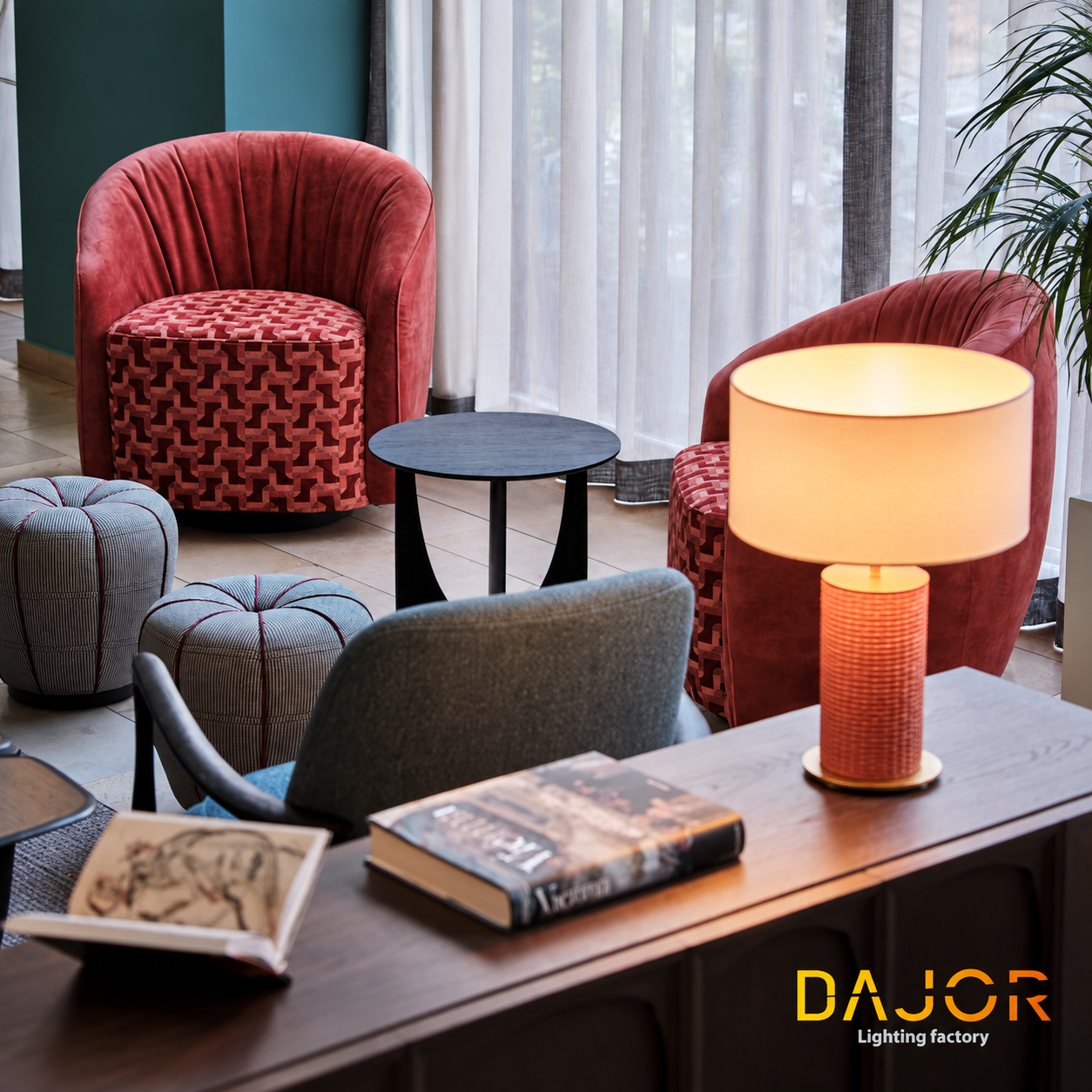 Zona de descanso con sillones rojos y lámpara de sobremesa encendida sobre mueble de madera, iluminación decorativa DAJOR.
