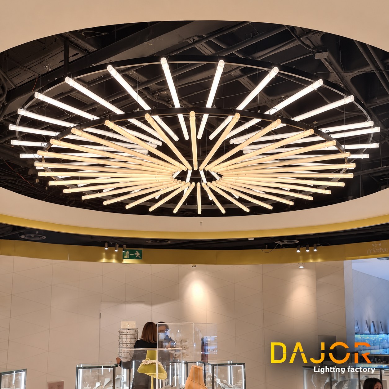 Luminaria circular suspendida dentro del hueco del techo sobre las vitrinas de joyería de El Corte Inglés Castellana.
